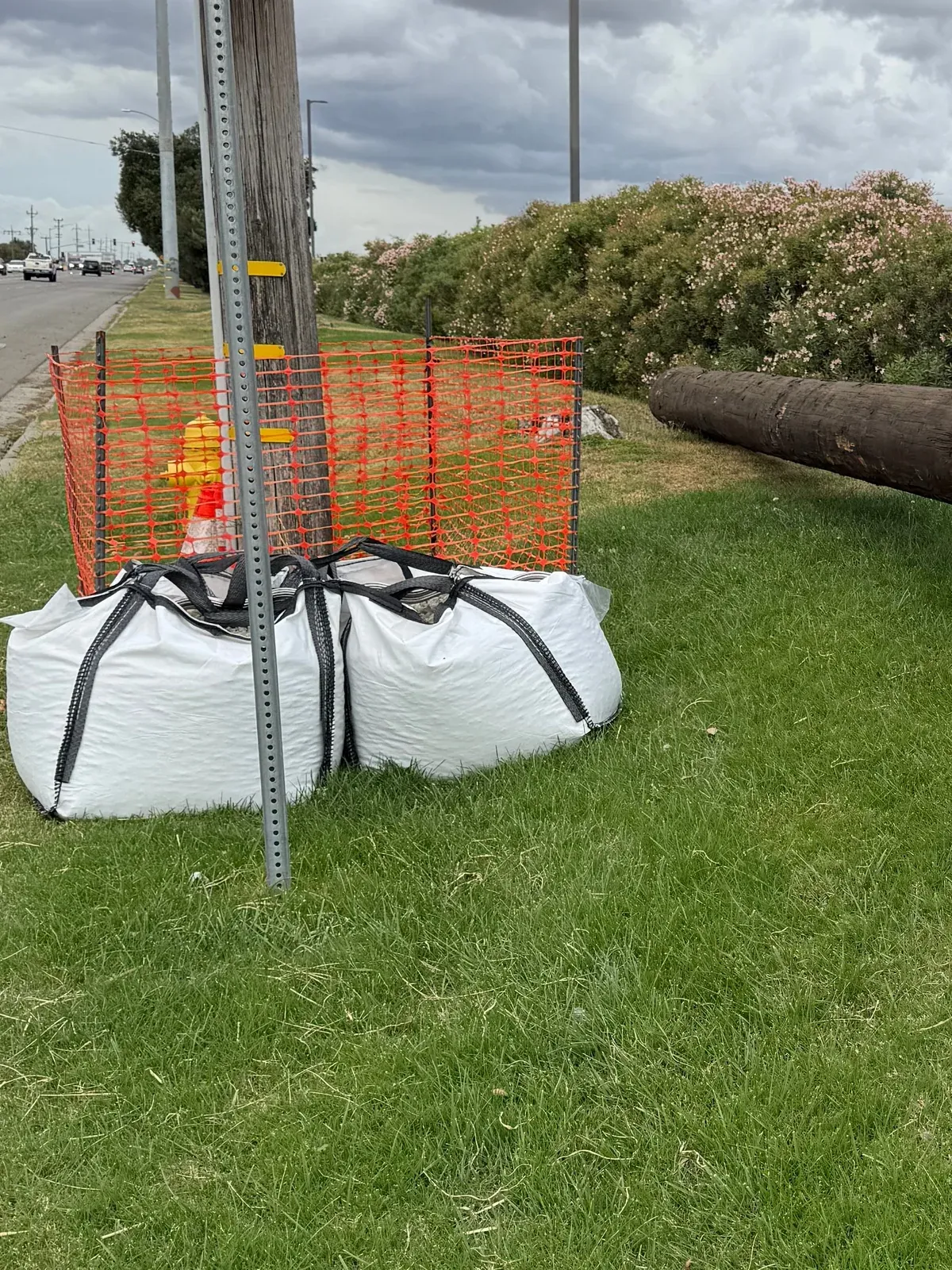 Bulk bags and safety fencing cribbing a timber pole laid out before setting