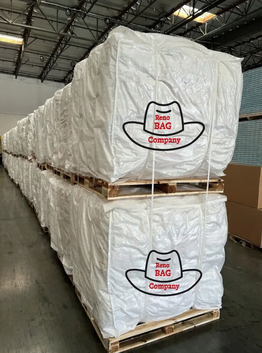 Food grade bulk bags printed with the Reno Bag Company logo stacked on warehouse pallets