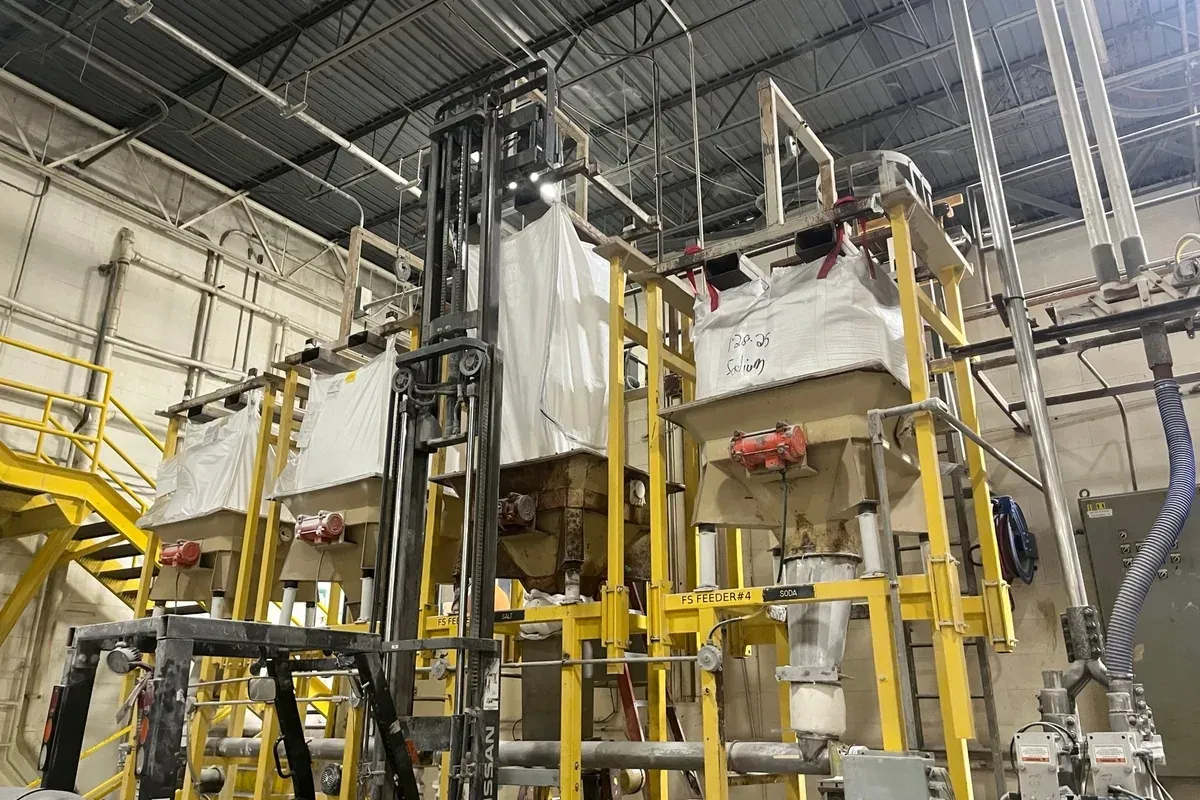 Bulk bag hanging at a plant unloading station above a discharge hopper